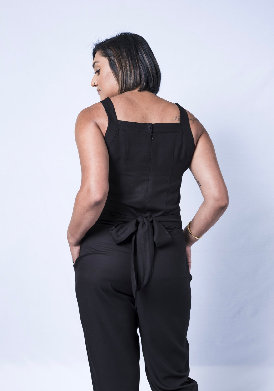All In One Jumpsuit Model showing back of jumpsuit. Waistband tied to back