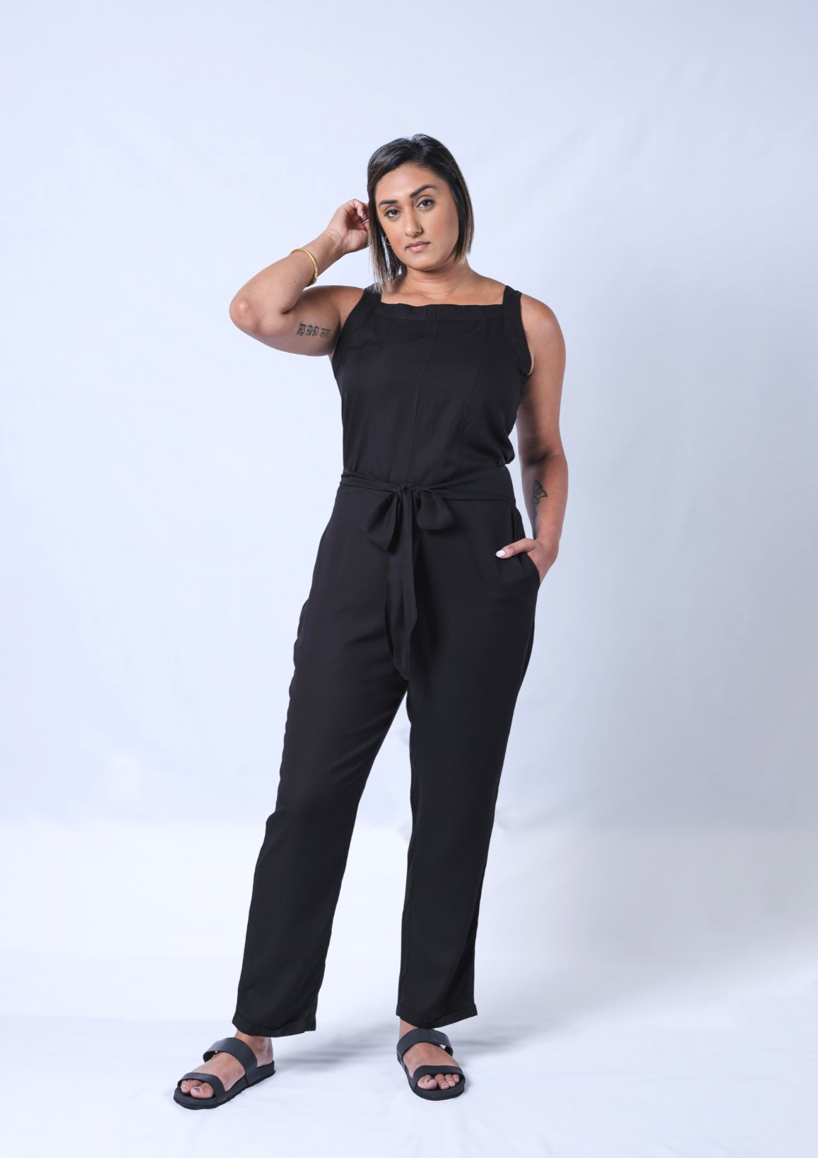 All In One Jumpsuit Model Standing showing front of jumpsuit. Waistband tied to front
