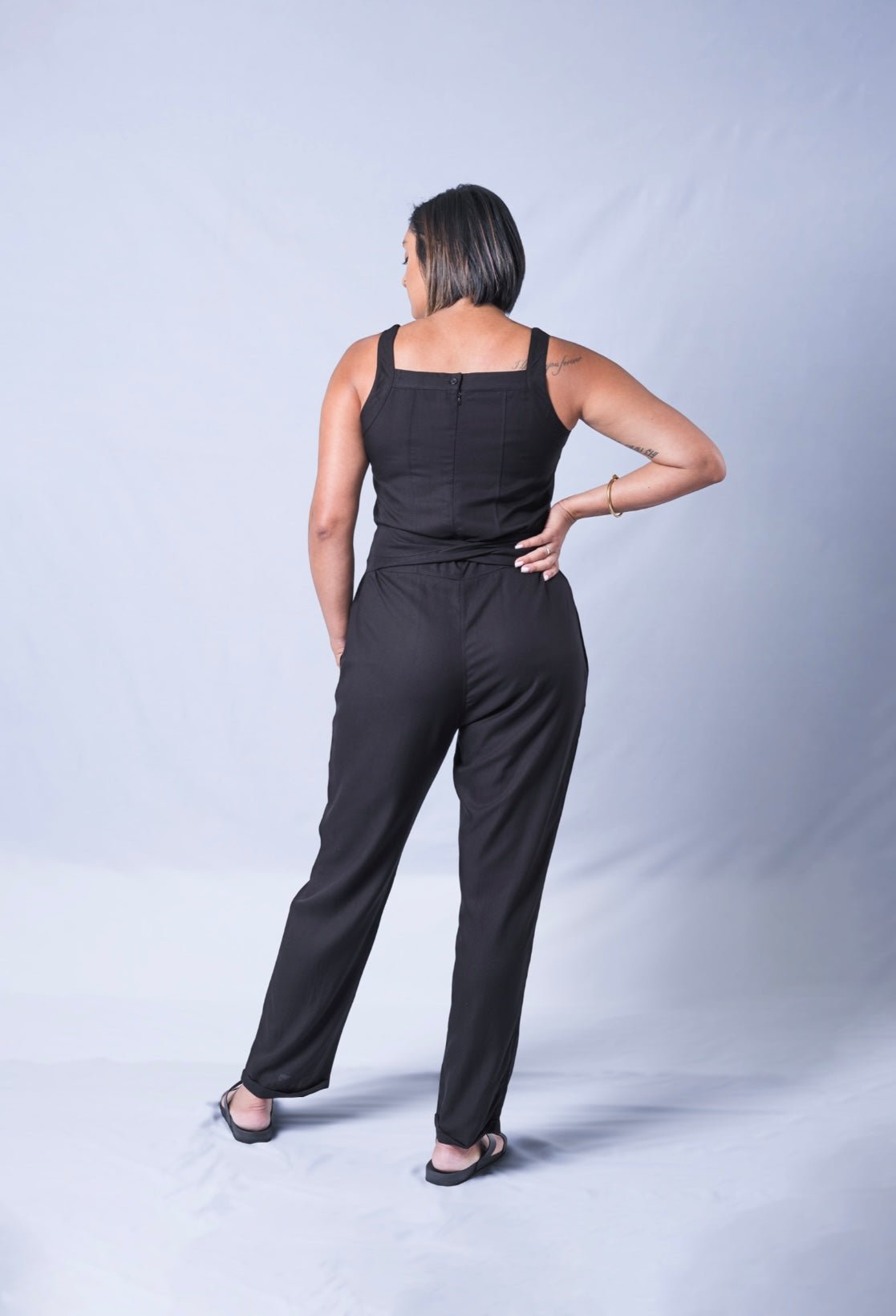 All In One Jumpsuit Model showing back of jumpsuit. Waistband tied to front