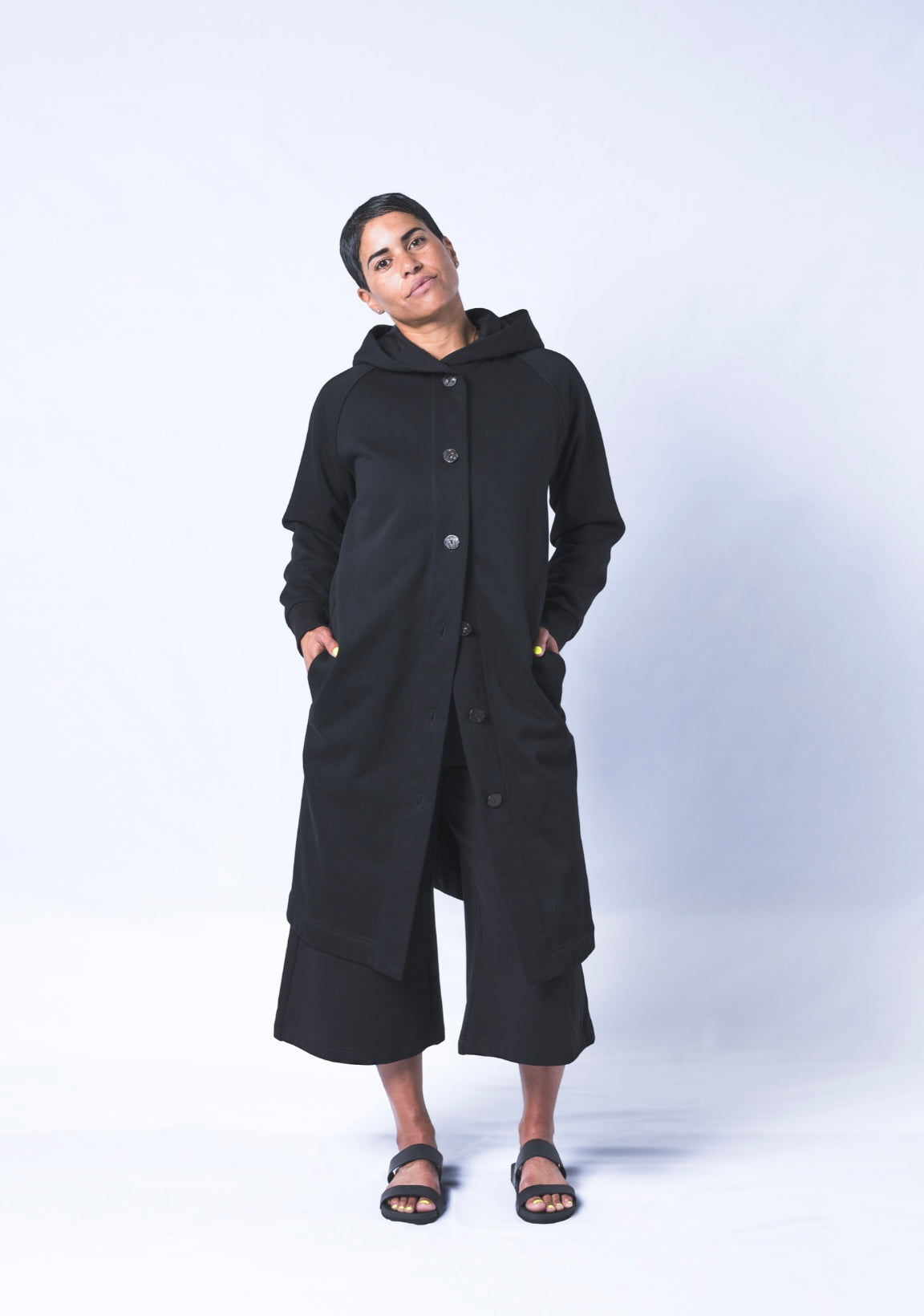 Somewhere between a cardigan and a coat...Its a Coatigan! Hand-picked black cotton poly blend fabric ensures lasting comfort no matter how many times you wash it. Features oversized hood for extra comfort and deep side pockets. Sizes Small-Large available.