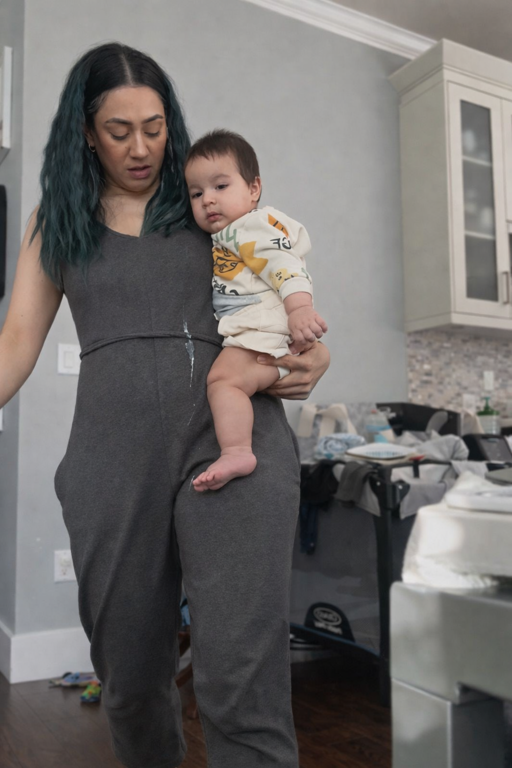 Woman holding a baby in a kitchen setting