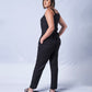 All In One Jumpsuit Model Standing to side showing side view. Waistband tied to back