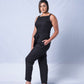 All In One Jumpsuit Model Standing showing side of the jumpsuit. Waistband tied to front and hand in pocket
