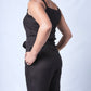 All In One Jumpsuit Model Standing showing closer view of the jumpsuit side. Waistband tied to front and hands in pocket